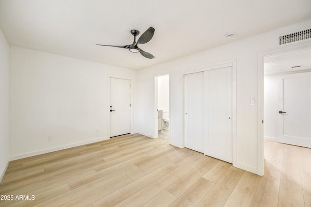 unfurnished bedroom with ceiling fan, ensuite bath, a closet, and light wood-type flooring