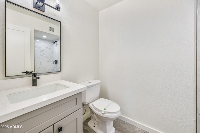 bathroom with vanity, walk in shower, and toilet