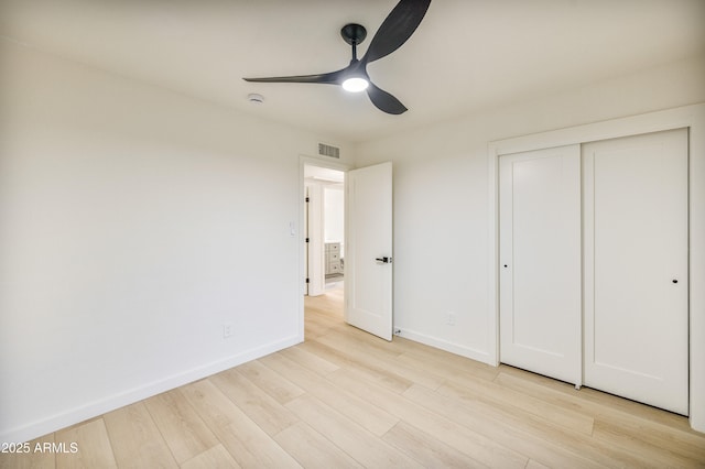 unfurnished bedroom with ceiling fan, light wood-type flooring, and a closet