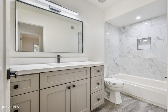 full bathroom with vanity, tiled shower / bath, and toilet