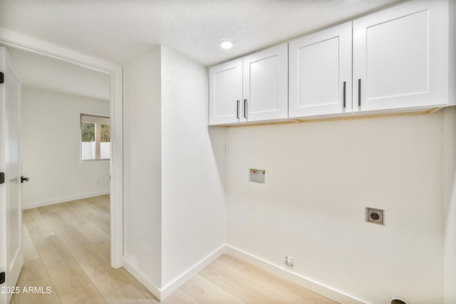 washroom featuring cabinets, hookup for an electric dryer, light hardwood / wood-style floors, and hookup for a washing machine