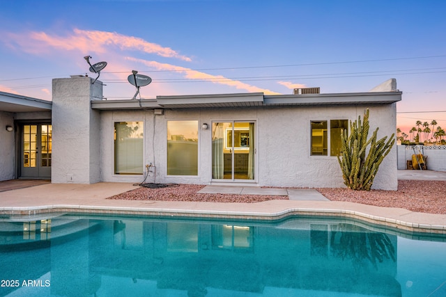 pool at dusk with a patio