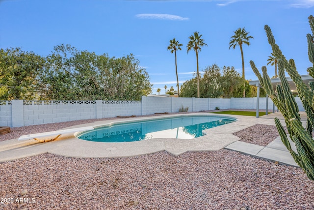 view of swimming pool featuring a diving board