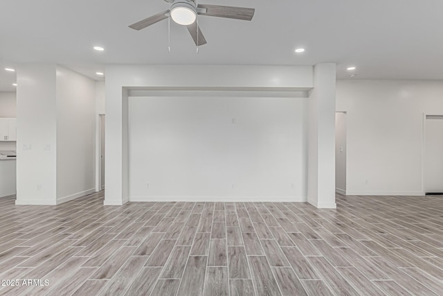 interior space featuring light wood finished floors, a ceiling fan, baseboards, and recessed lighting