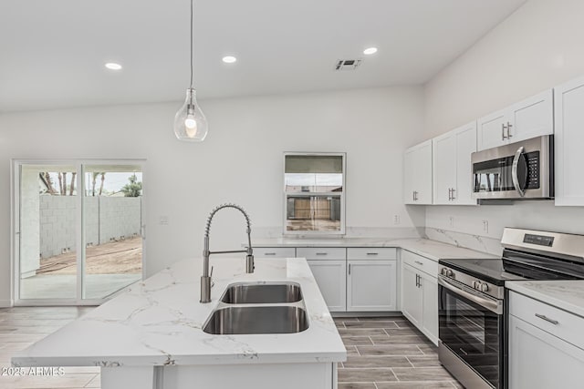 kitchen with a sink, stainless steel appliances, a center island with sink, visible vents, and recessed lighting