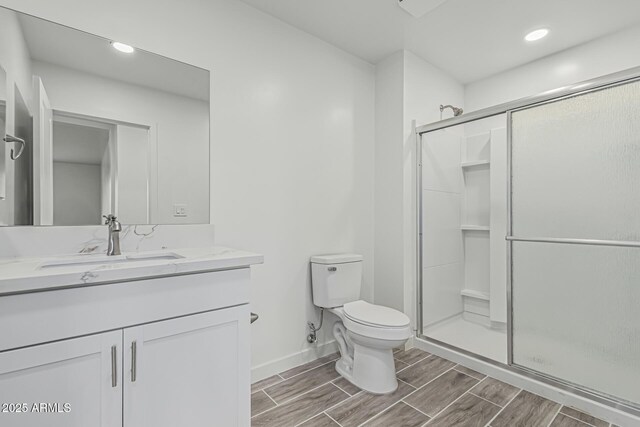 full bathroom with wood finish floors, vanity, toilet, and a stall shower