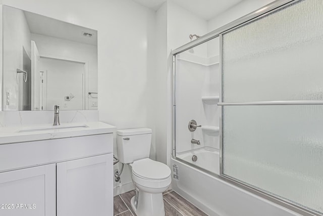 full bathroom featuring bath / shower combo with glass door, toilet, visible vents, wood finished floors, and vanity