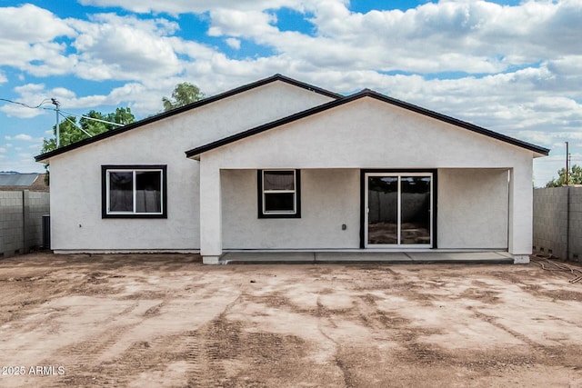 back of house with fence and stucco siding