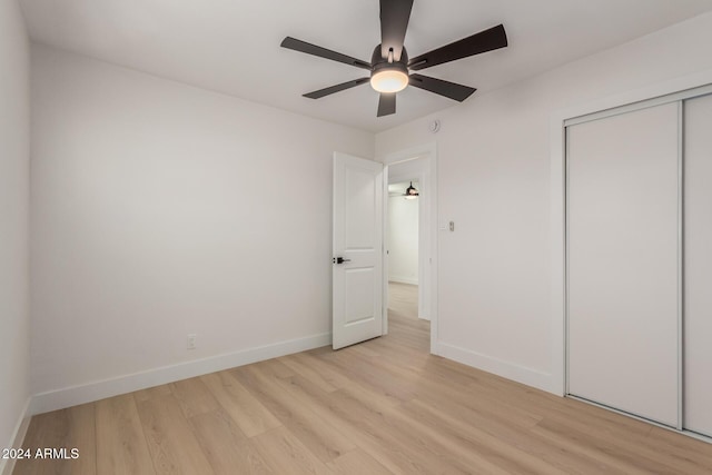 unfurnished bedroom featuring a closet, light hardwood / wood-style flooring, and ceiling fan