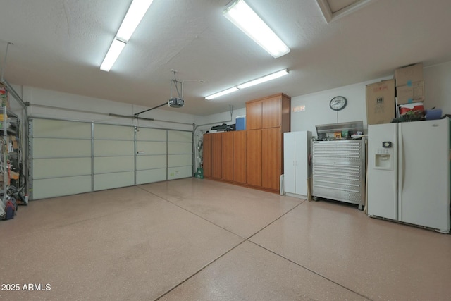 garage featuring a garage door opener and white fridge with ice dispenser