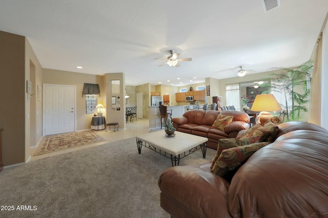 carpeted living room with ceiling fan