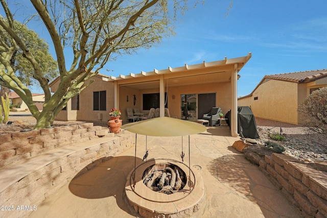 back of house featuring a fire pit and a patio area