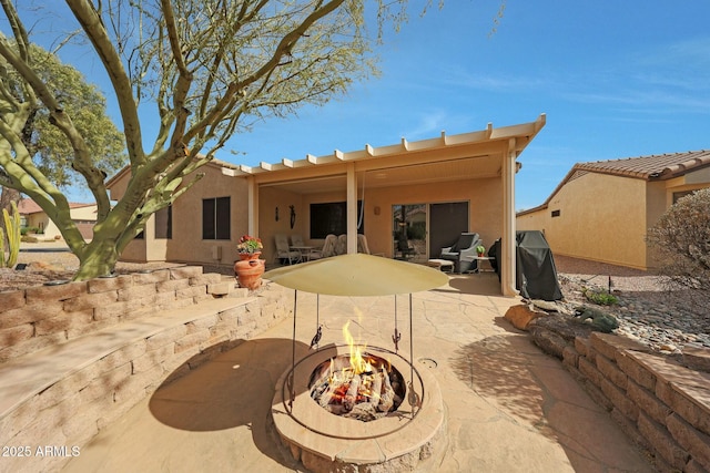 back of house with a patio area and an outdoor fire pit