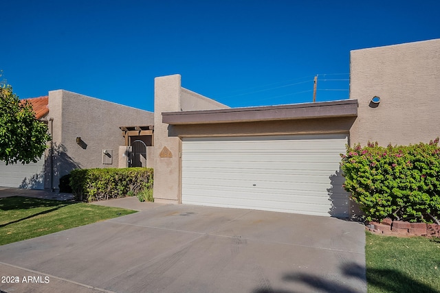 view of front of property with a garage and a front lawn