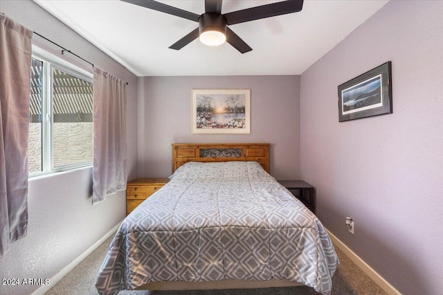 carpeted bedroom featuring multiple windows and ceiling fan