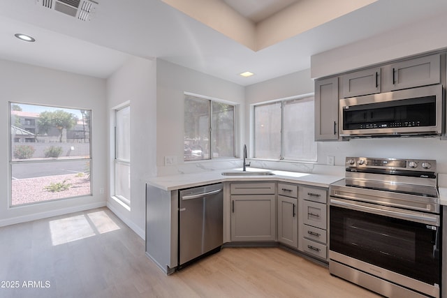 101 N 7th St Unit 168, Phoenix, AZ 85034 - kitchen featuring stainless steel appliances, gray cabinets, light wood-style flooring, recessed lighting, and light stone countertops