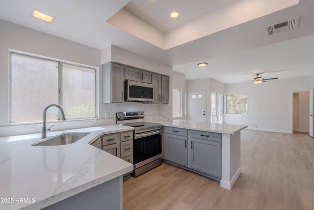 101 N 7th St Unit 168, Phoenix, AZ 85034 - kitchen with appliances with stainless steel finishes, gray cabinets, a peninsula, light wood finished floors, and recessed lighting