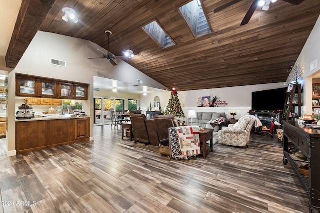 living room with dark hardwood / wood-style flooring, a skylight, ceiling fan, high vaulted ceiling, and wooden ceiling