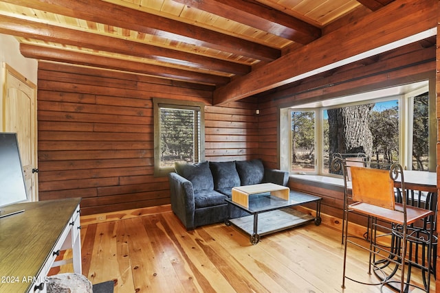 living room with plenty of natural light, light wood-type flooring, and beamed ceiling