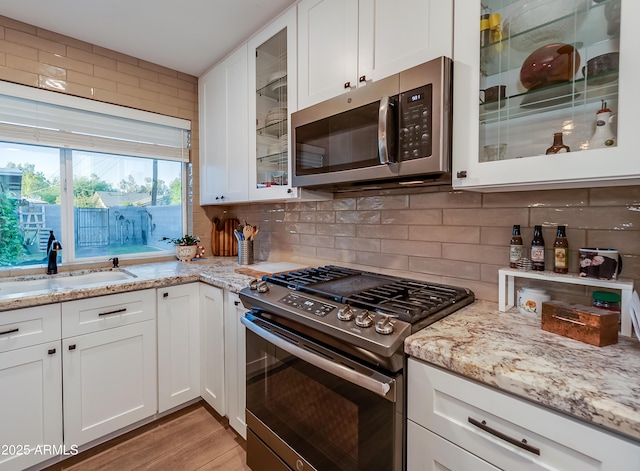 7226 E Virginia Ave, Scottsdale, AZ 85257 - kitchen featuring appliances with stainless steel finishes, a sink, white cabinets, and light stone countertops