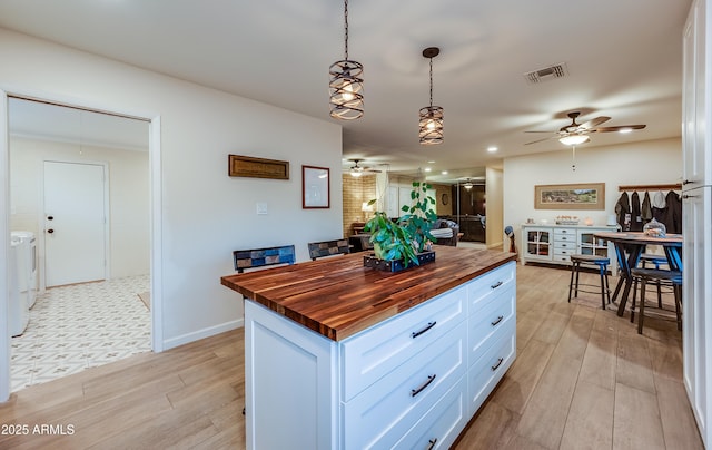 7226 E Virginia Ave, Scottsdale, AZ 85257 - kitchen featuring wood counters, ceiling fan, washing machine and clothes dryer, and light wood-style flooring