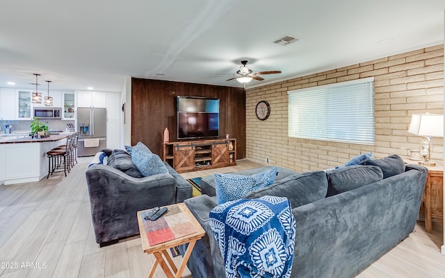 7226 E Virginia Ave, Scottsdale, AZ 85257 - living room with brick wall, a ceiling fan, and wooden walls
