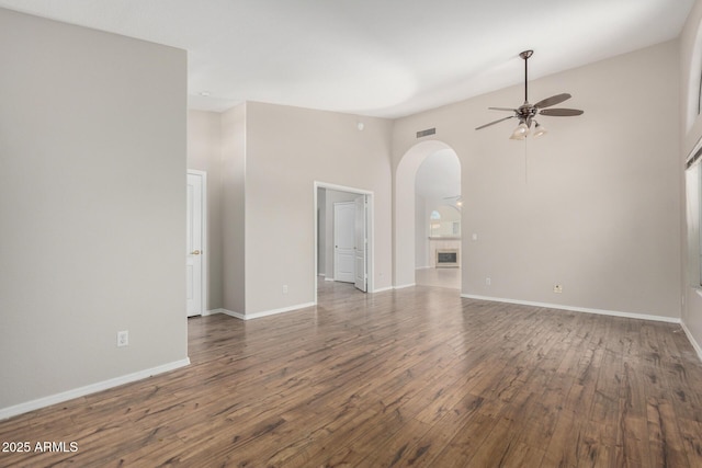 1915 E Golden Ct, Chandler, AZ 85225 - unfurnished living room featuring arched walkways, wood finished floors, baseboards, and ceiling fan