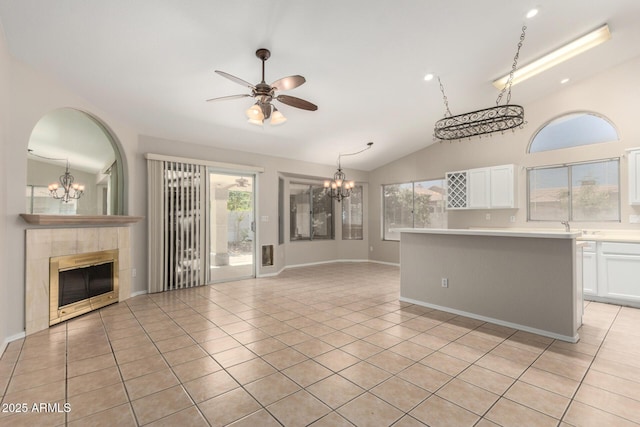 1915 E Golden Ct, Chandler, AZ 85225 - unfurnished living room with a wealth of natural light, vaulted ceiling, ceiling fan with notable chandelier, a tile fireplace, and light tile patterned floors