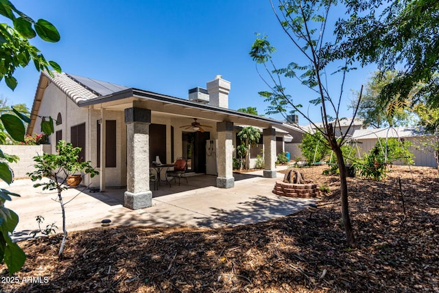 1915 E Golden Ct, Chandler, AZ 85225 - back of house featuring a ceiling fan, roof mounted solar panels, an outdoor fire pit, a patio, and stucco siding