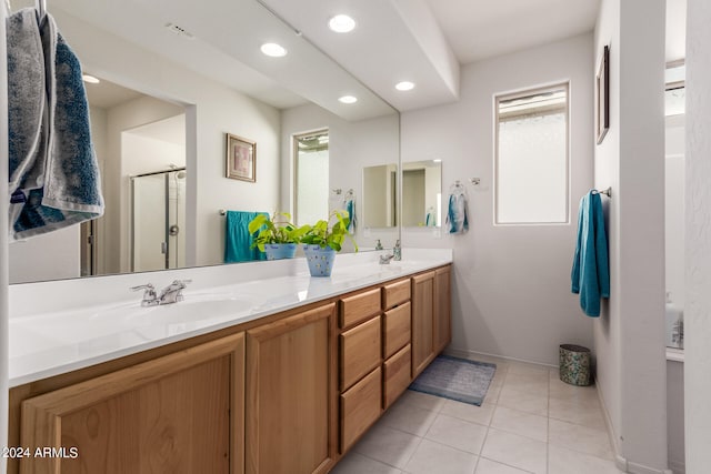 bathroom with tile patterned flooring, a shower with door, and vanity