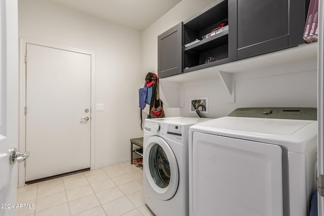 washroom with light tile patterned floors, cabinets, and independent washer and dryer