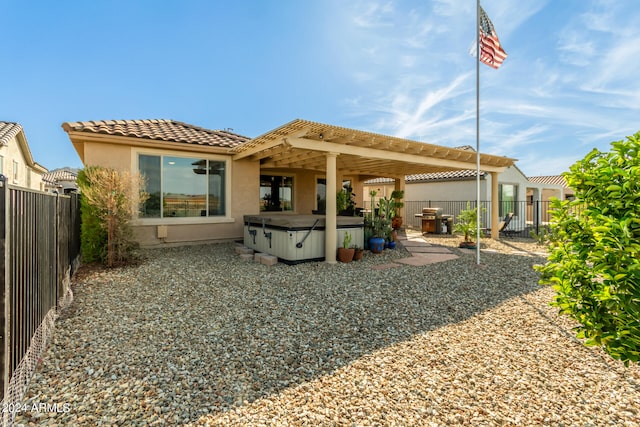 rear view of house with a patio and a hot tub