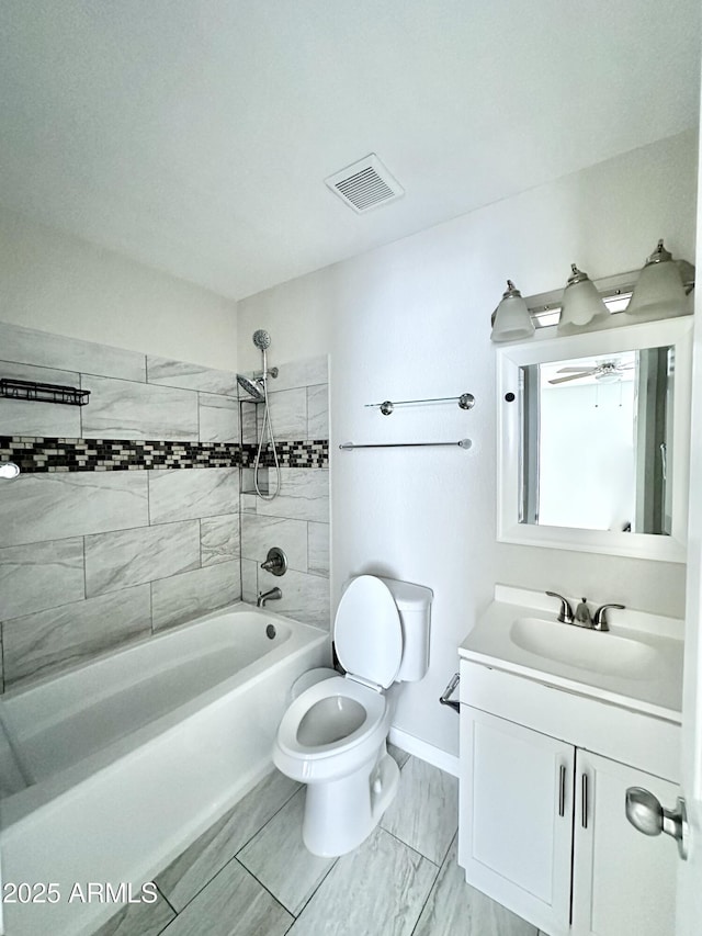 full bathroom with tiled shower / bath combo, vanity, and toilet