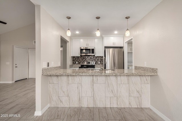 kitchen featuring light stone counters, stainless steel appliances, kitchen peninsula, and white cabinets