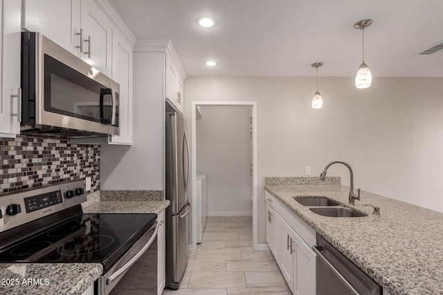 kitchen with decorative light fixtures, white cabinetry, sink, stainless steel appliances, and light stone countertops