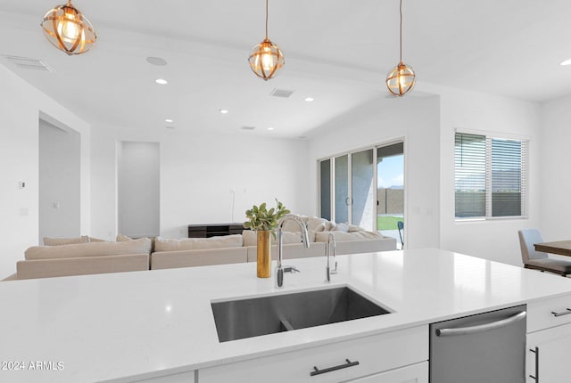 kitchen featuring white cabinetry, sink, stainless steel dishwasher, and decorative light fixtures