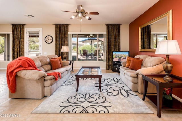 living room with a wealth of natural light, ceiling fan, and light tile patterned floors