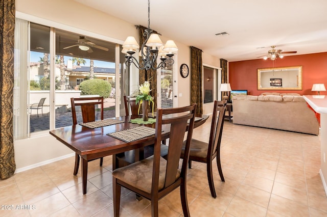 dining space with ceiling fan with notable chandelier and light tile patterned floors