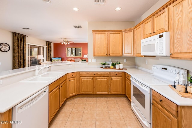 kitchen featuring sink, light tile patterned floors, white appliances, and kitchen peninsula