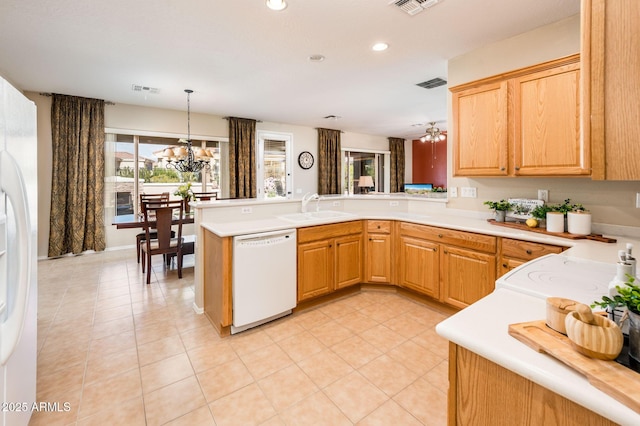 kitchen with decorative light fixtures, sink, a chandelier, kitchen peninsula, and white appliances