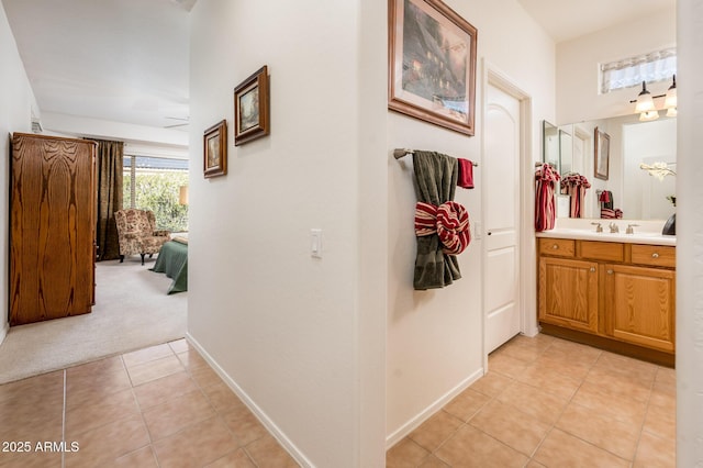 hall featuring light tile patterned floors and sink