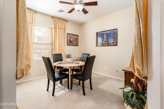 dining area featuring ceiling fan and light carpet