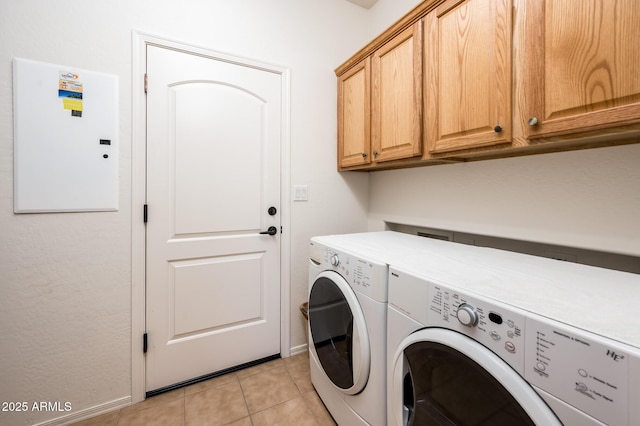 laundry area featuring independent washer and dryer, light tile patterned floors, and cabinets