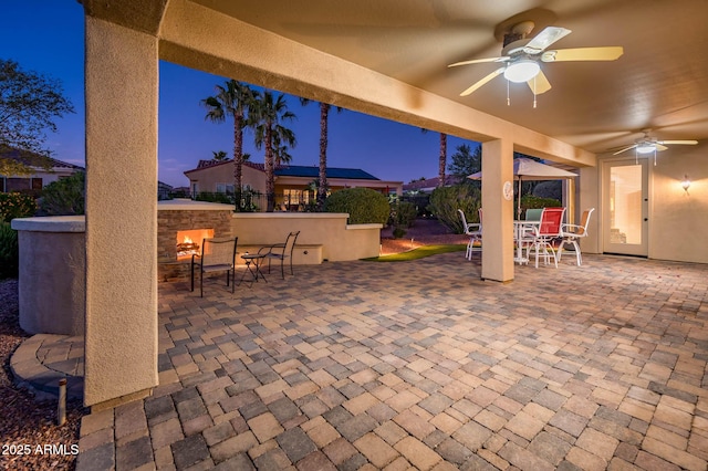 patio terrace at dusk featuring ceiling fan