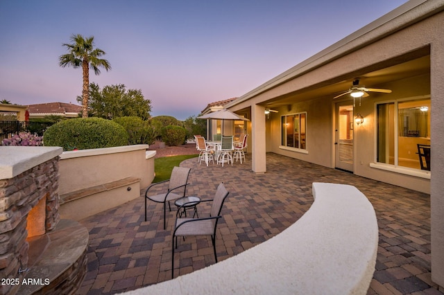 patio terrace at dusk featuring ceiling fan