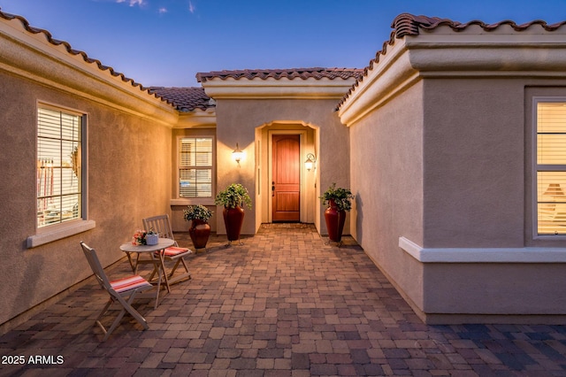 exterior entry at dusk with a patio area