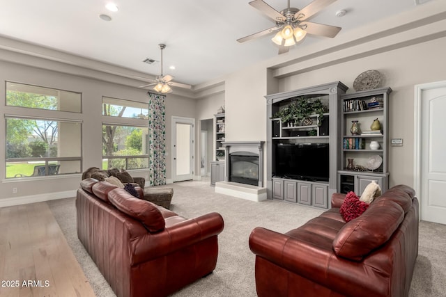 living area featuring recessed lighting, visible vents, a glass covered fireplace, ceiling fan, and baseboards