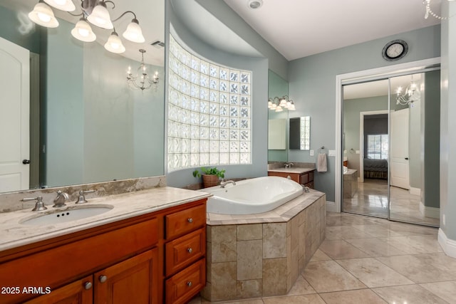 ensuite bathroom featuring two vanities, visible vents, an inviting chandelier, connected bathroom, and a sink