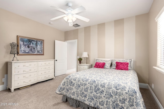 bedroom featuring carpet floors, visible vents, a ceiling fan, baseboards, and wallpapered walls