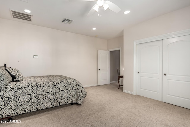 bedroom with recessed lighting, visible vents, a closet, and light colored carpet